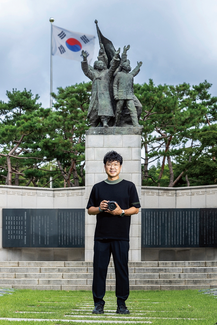 서울 서대문독립공원 3&middot;1독립선언기념탑 앞에 선 김동우 작가. 2017년부터 11개국을 다니며 국외 독립운동 사적지와 독립운동가 후손을 사진으로 기록하고 있다. 6 사진 C영상미디어