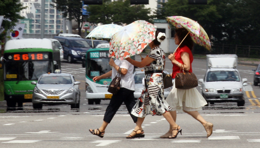 전국적으로 폭염특보가 내려진 25일 시민들이 양산을 쓰고 서울시내를 걸어가고 있다.(사진=저작권자 (c) 연합뉴스. 무단전재-재배포금지)