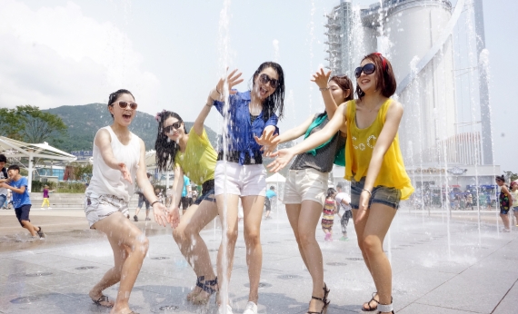스카이타워를 배경으로 여성 관람객들이 바닥분수 물놀이를 즐기고 있다. 