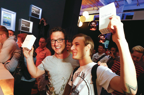 지난 5월 29일 독일 베를린에서 삼성전자 갤럭시S Ⅲ를 구입한 소비자들이 제품을 들어보이며 기뻐하고 있다.
