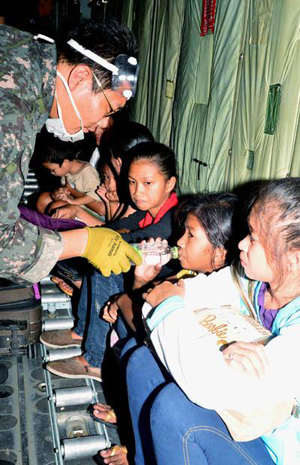 공군 장병이 C-130수송기 안에서 태풍 피해지역에서 긴급 후송한 어린이들에게 생수를 먹이고 있다.(사진=국방일보)