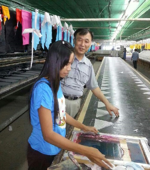 정명기씨가 ALL ACE 미얀마 양곤 공장에서 한 직원에게 작업지도를 하고 있다.