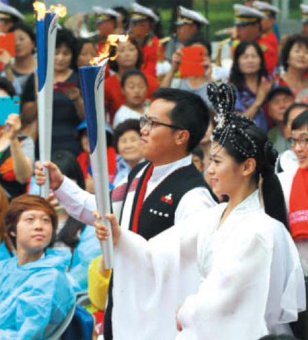 8월 13일 오후 인천 종합문화예술회관에서 열린 2014 인천아시아경기대회 성화합화식에서 인도 전통의상을 입은 청년과 칠선녀 의상을 한 여인이 각각 해외 성화와 마니산 성화를 들고 입장하고 있다.