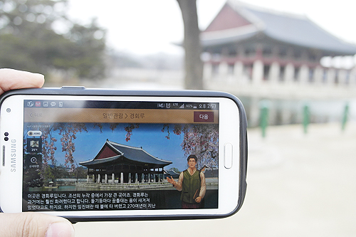 <내손안의 경복궁> 앱을 통해 경희루에 대한 해설을 듣고 있다.