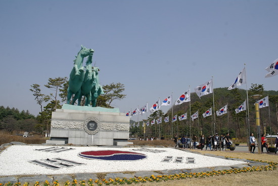 현충원 입구에 세워진 태극기와 말의 힘찬 기를 받으며 대한민국 만세
