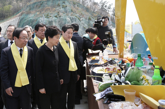 박근혜 대통령이 세월호 1주년을 맞은 16일 오후 전남 진도군 팽목항을 방문, 희생자와 실종자를 위해 마련된 추모 메시지와 음식들이 놓인 단 앞을 지나가고 있다. (사진=청와대) 