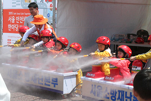 화재안전 프로그램에 참가한 아이들이 소화기 사용법을 배우고 있다.