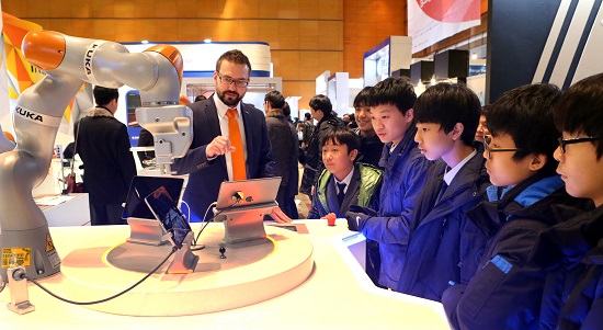 쿠카에서 출품한 로봇팔에 대해 김지민군 등 오산 운암중 학생들이 호기심을 보이고 있다. 쿠카의 독일인 엔지니어는 한국 학생들의 관심에 놀랐다며 칭찬을 아끼지 않았다.