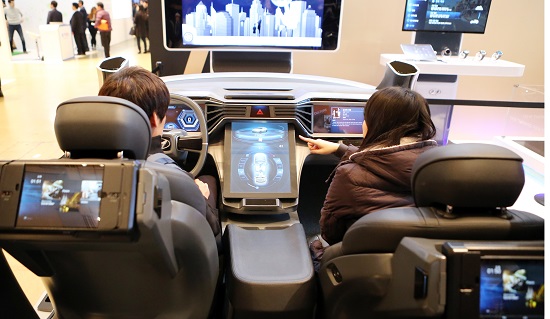 직장인 김대섭, 박란희씨가 스마트형 자동차 부스에서 미래 자동차의 다양한 신기술을 살펴보고 있다.