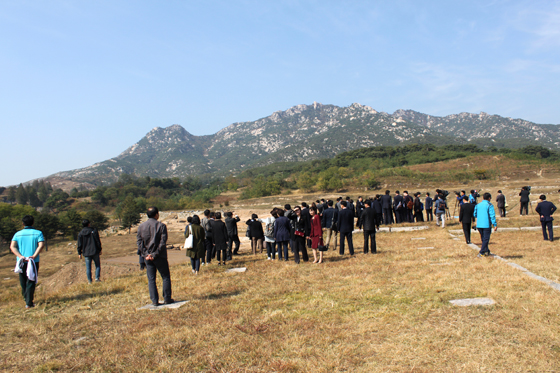 개성 만월대를 찾은 남북공동 발굴 조사단. 임신한 여인이 누워있는 모습과 닮았다는 송악산이 멀리 보인다. (사진 = 인터아트채널)