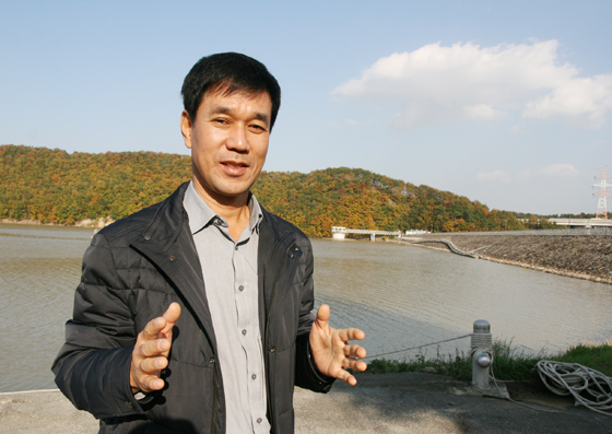 정병건 주무관이 회야댐 앞에서 자신이 개발한 청소선에 대해 설명하고 있다. 