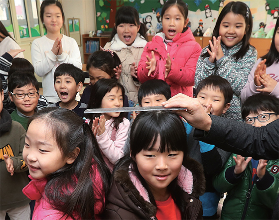 1월 31일 오전 겨울방학을 마치고 개학한 경기 수원시 장안구 송림초등학교 2학년 교실에서 학생들이 오랜만에 만난 친구와 키를 재보고 있다. (사진=저작권자(c) 연합뉴스, 무단 전재-재배포 금지)