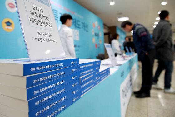 지난해 12월 15일 오후 서울 국립중앙도서관에서 열린 체육특기자 제도개선 심포지엄에서 행사 관계자가 참석자들에게 2017학년도 체육특기자 대입 전형 요강을 배포하고 있다. (사진=저작권자(c) 연합뉴스, 무단 전재-재배포 금지) 