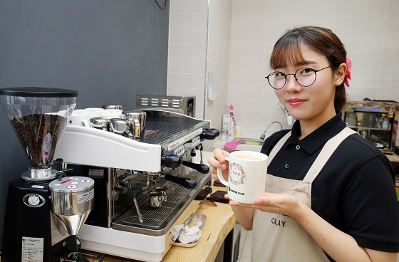 안지현 씨가 자신이 직접 제조한 커피를 들어보이며 포즈를 취하고 있다.