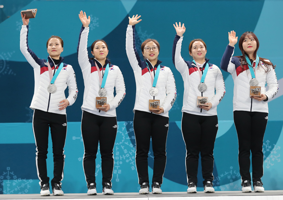 25일 강원도 강릉 컬링센터에서 열린 2018평창올림픽 컬링 여자 결승에서 은메달을 차지한 한국 컬링 대표팀이 시상대에 올라 손인사 하고 있다. (사진=저작권자(c) 연합뉴스, 무단 전재-재배포 금지)