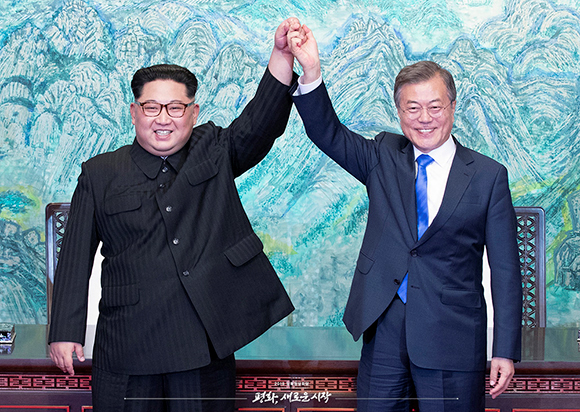 문재인 대통령과 김정은 위원장이 ‘판문점 선언문’에 서명한 뒤 손을 들어 보이고 있다.