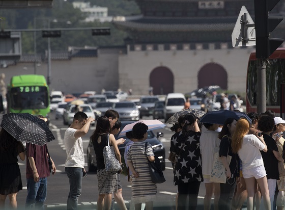 폭염이 이어지고 있는 17일 오전 서울 세종로사거리에서 시민들이 보행신호를 기다리고 있다.(사진=저작권자(c) 연합뉴스, 무단 전재-재배포 금지)