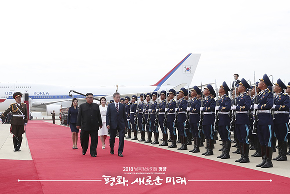 문재인 대통령과 부인 김정숙 여사가 18일 오전 평양 순안공항에서 열린 공식 환영식에서 김정은 국무위원장 및 리설주 여사와 의장대를 사열하고 있다. ⓒ 평양사진공동취재단