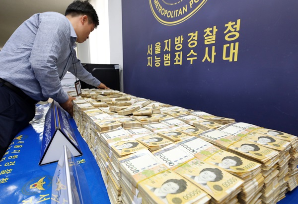 지난해 서울경찰청 지능범죄수사대(지수대)에서 경찰 관계자가 불법 스포츠 도박 사이트를 운영한 일당으로부터 압수한 현금을 진열하고 있다.(출처=뉴스1)