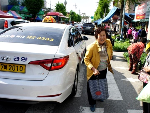 100원 택시를 타고 시장에 나온 어르신이 밝게 웃고 있다.(출처=광양시)