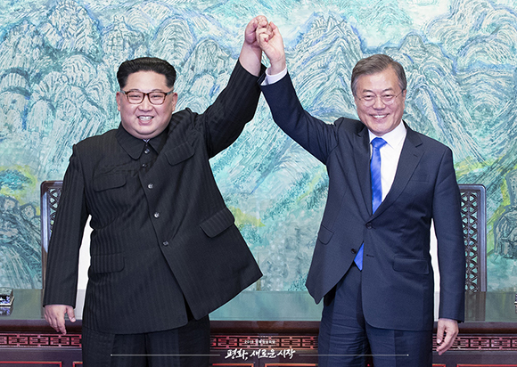 문재인 대통령과 김정은 위원장이 ‘판문점 선언문’에 서명한 뒤 손을 들어 보이고 있다.