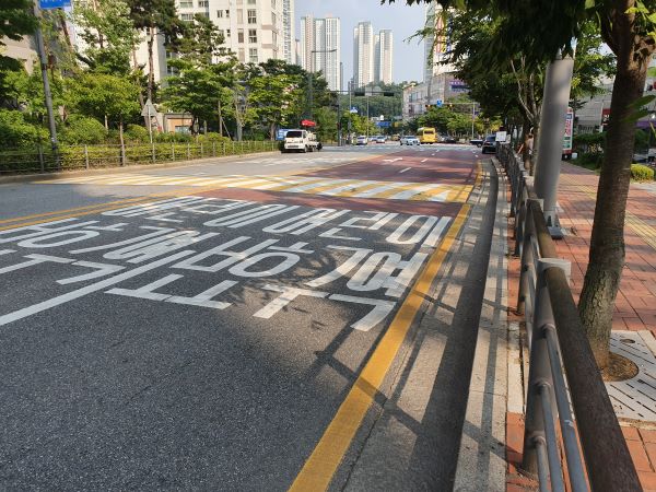 어린이 보호구역을 알리는 글자와 자주빛 아스팔트