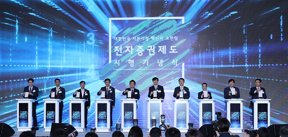 조국 법무부 장관(왼쪽 여섯번째부터), 은성수 금융위원장을 비롯한 참석자들이 16일 오전 서울 여의도 콘래드 호텔에서 열린 전자증권제도 시행 기념식에서 종이 증권을 세절기에 넣는 퍼포먼스를 하고 있다. (저작권자(c) 연합뉴스, 무단 전재-재배포 금지) 