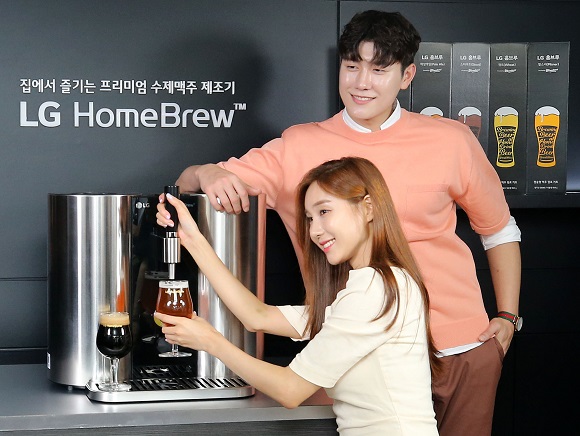지난 7월 16일 서울 정동 주한 영국대사관에서 열린 LG 홈 캡슐 맥주 제조기 '홈브루' 출시 행사에서 모델들이 간편하게 맥주를 제조할 수 있는 기기를 소개하고 있다. (저작권자(c) 연합뉴스, 무단 전재-재배포 금지)