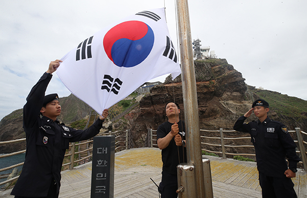 경북 울릉군 독도에서 독도경비대원들이 태풍 비바람으로 훼손된 태극기를 내리고 새 태극기를 게양하고 있다. (사진=저작권자(c) 연합뉴스, 무단 전재-재배포 금지)