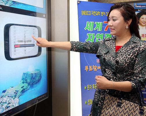  제주-세계 7대 자연경관 홍보대사로 위촉된 로즈장(Rose Jang. 한국명 장미영)이 제주도청에서 터치 스크린을 통해 세계 7대 자연경관 선정 투표에서 제주를 지지하는 한표를 행사하고 있다. 