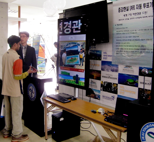 제주도 관광공사 내 웰컴센터에서 한 외국인이 증강현실 용지를 AR투표기화면에 비추고 있다.