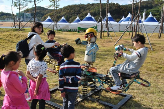 아이들이 공주보 주변에 마련된 친환경 놀이터에서 정크아트작품인 시소를 타며 즐거워하고 있다.