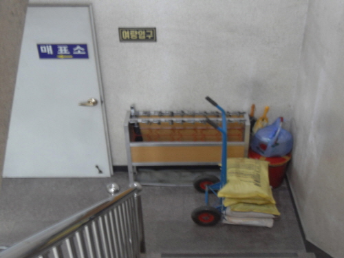 목욕탕 입구 비상구 공간에 설치한 구조물, 구석에 쌓아둔 가재도구, 통로 중앙에 버젓이 세워둔 짐수레 등이 눈에 거슬린다.