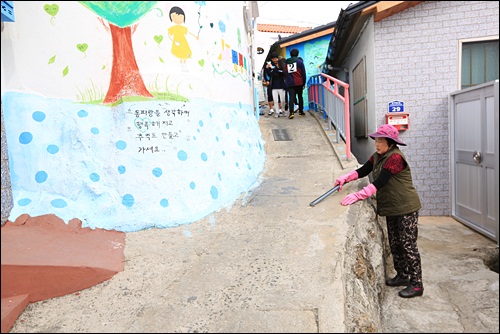 관광객들이 버린 쓰레기를 청소하고 있는 동피랑 주민 안외선씨 