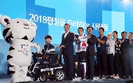문재인 대통령이 7월 24일 오후 평창 알펜시아 리조트에서 열린 'G-200, 2018 평창을 준비하는 사람들' 평창 동계올림픽·패럴림픽 성공 다짐대회에 참석해 전동 휠체어를 탄 자원봉사자 권현우 씨와 보조를 맞추고 있다. 
