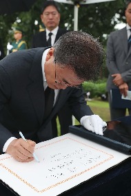 문재인 대통령이 광복절인 8월 15일 오전 서울 용산구 백범 김구 선생의 묘역에서 참배를 마치고 방명록을 작성하고 있다.