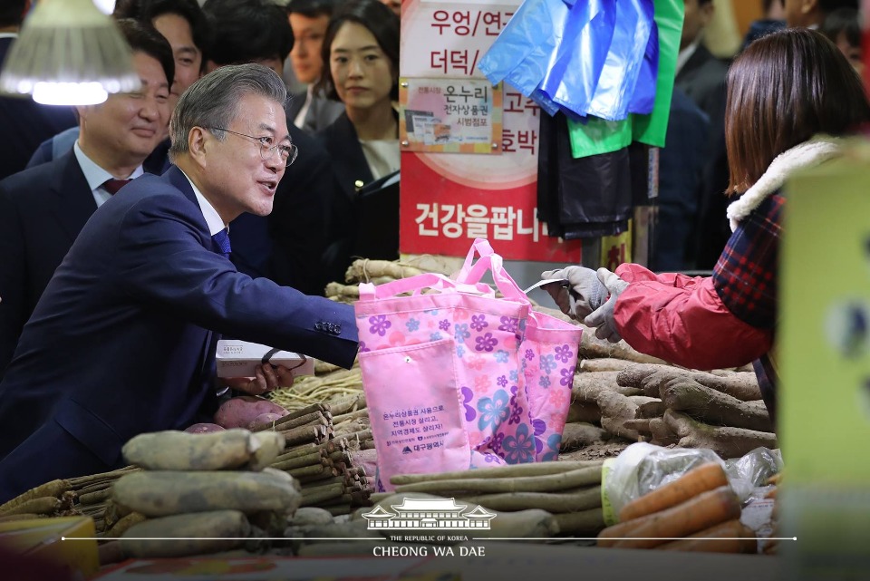 문재인 대통령이 22일 대구 북구 칠성시장에서 물건을 구매하고 있다. (사진출처 : 청와대 페이스북)