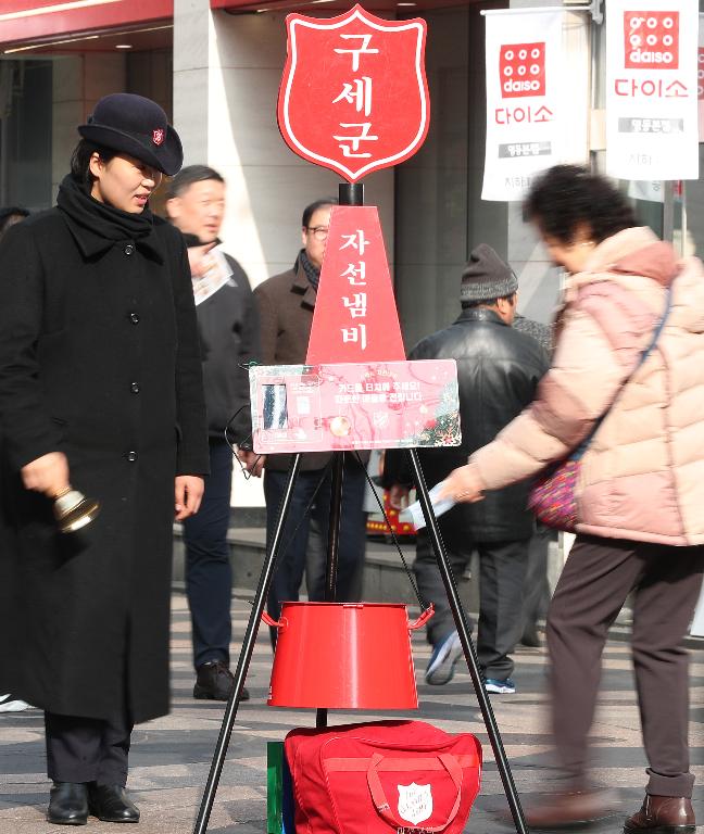 11일 구세군사관학교 학생이 서울 명동거리에 설치된 자선냄비 앞에서 모금 봉사활동을 펼치고 있다. 모금기간은 올해 12월 31일까지이며 전국 17개 시,도에 353개의 자선냄비가 설치되어 모금활동을 펼칠 예정이다.