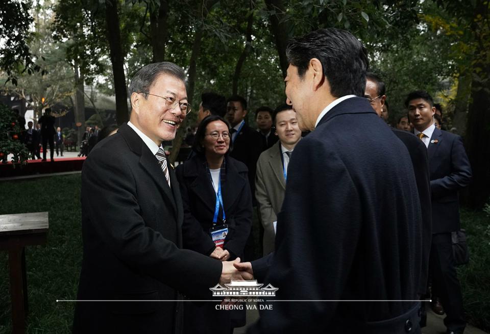 문재인 대통령과 아베 신조 일본 총리가 24일 중국 쓰촨성 청두 두보초당에서 열린 한중일 협력 20주년 기념 제막식에서 악수하고 있다.
