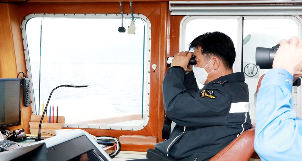 김홍희 해양경찰청장이 불법 외국어선의 진입을 차단하며 강력 대응하는 3008함에서 중국어선을 확인하고 있다.