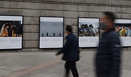 서울 중구 서울도서관 외벽에 서울시와 함께하는 2020 서울글로벌포토저널리즘 사진전이 설치되어 출근하는 시민들이 지나가며 보고 있다. 