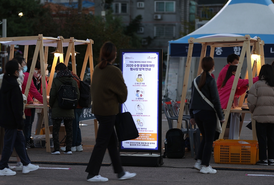 한여름 축제인 수원 문화재 야행이 올해는 코로나19 확산 방지를 위해 가을축제로 열렸다. 이날 관람객들이 화성행궁 일대를 체험 행사 없이 워킹 스루 형태의 관람 방식으로 야경을 감상하고 있다. 