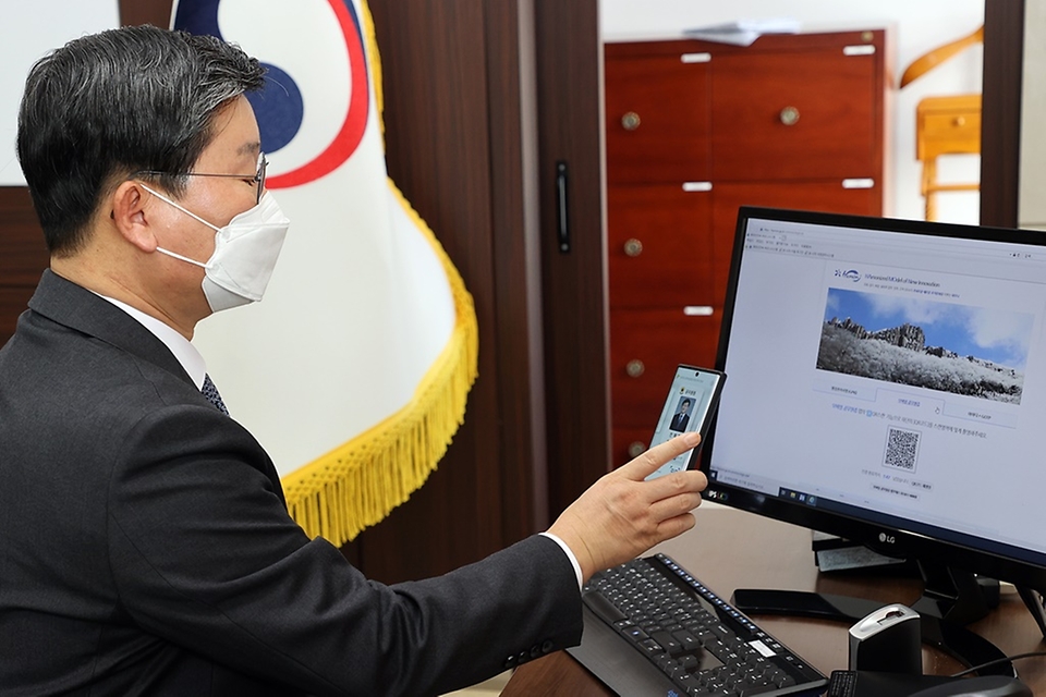 전해철 행정안전부 장관이 13일 오전 정부세종2청사 집무실에서 모바일 공무원증으로 행정안전부 업무시스템에 로그인을 시연해 보고 있다.