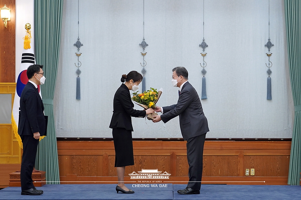 문재인 대통령이 21일 오전 청와대에서 열린 김진욱 초대 고위공직자범죄수사처장 임명장 수여식에서 김 공수처장의 부인에게 꽃다발을 전하고 있다.