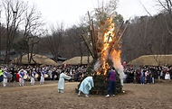 28일 봄이 찾아온 듯 포근한 오후 경기도 용인시 한국민속촌에서 보름이 바로 지난 일요일, 민속촌을 방문한 관람객들이 참석한 가운데 정월대보름 달집태우기를 하고 있다. 정월대보름에 생솔가지와 나뭇더미를 쌓아 ‘달집’을 짓고, 달이 떠오르면 불을 놓아 한 해의 액운을 막고 복을 기원했다고 한다.