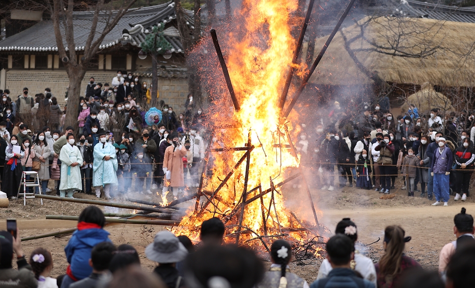 28일 봄이 찾아온 듯 포근한 오후 경기도 용인시 한국민속촌에서 보름이 바로 지난 일요일, 민속촌을 방문한 관람객들이 참석한 가운데 정월대보름 달집태우기를 하고 있다. 정월대보름에 생솔가지와 나뭇더미를 쌓아 ‘달집’을 짓고, 달이 떠오르면 불을 놓아 한 해의 액운을 막고 복을 기원했다고 한다.