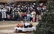 28일 봄이 찾아온 듯 포근한 오후 경기도 용인시 한국민속촌에서 보름이 바로 지난 일요일, 민속촌을 방문한 관람객들이 참석한 가운데 정월대보름 달집태우기를 하고 있다. 정월대보름에 생솔가지와 나뭇더미를 쌓아 ‘달집’을 짓고, 달이 떠오르면 불을 놓아 한 해의 액운을 막고 복을 기원했다고 한다.