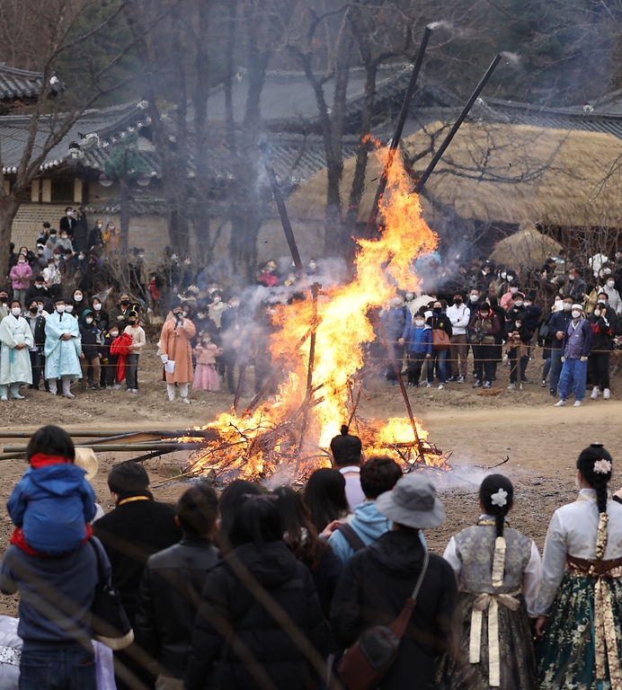 28일 봄이 찾아온 듯 포근한 오후 경기도 용인시 한국민속촌에서 보름이 바로 지난 일요일, 민속촌을 방문한 관람객들이 참석한 가운데 정월대보름 달집태우기를 하고 있다. 정월대보름에 생솔가지와 나뭇더미를 쌓아 ‘달집’을 짓고, 달이 떠오르면 불을 놓아 한 해의 액운을 막고 복을 기원했다고 한다.