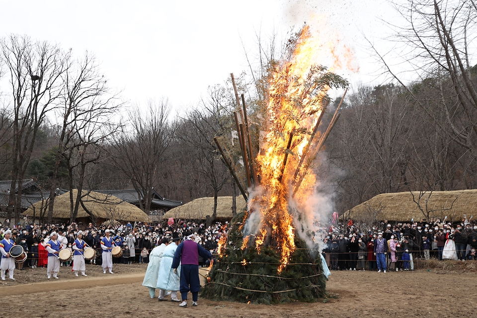 28일 봄이 찾아온 듯 포근한 오후 경기도 용인시 한국민속촌에서 보름이 바로 지난 일요일, 민속촌을 방문한 관람객들이 참석한 가운데 정월대보름 달집태우기를 하고 있다. 정월대보름에 생솔가지와 나뭇더미를 쌓아 ‘달집’을 짓고, 달이 떠오르면 불을 놓아 한 해의 액운을 막고 복을 기원했다고 한다.