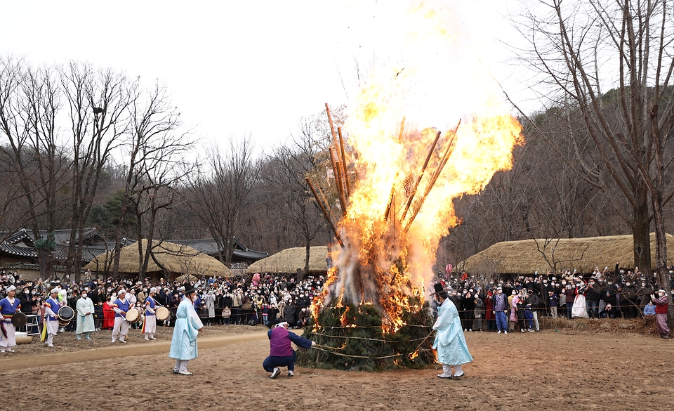 28일 봄이 찾아온 듯 포근한 오후 경기도 용인시 한국민속촌에서 보름이 바로 지난 일요일, 민속촌을 방문한 관람객들이 참석한 가운데 정월대보름 달집태우기를 하고 있다. 정월대보름에 생솔가지와 나뭇더미를 쌓아 ‘달집’을 짓고, 달이 떠오르면 불을 놓아 한 해의 액운을 막고 복을 기원했다고 한다.